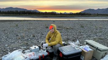Photo of Ben Peterson filtering a sample at sunset