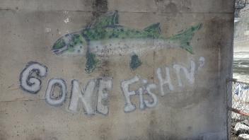 Graffiti of a fish was the words "Gone Fishing" painted on dam wall