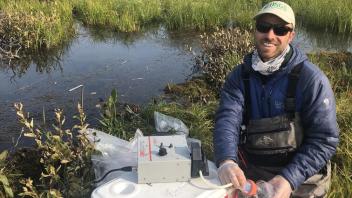 Brett Poulin (principle investigator) sampling a wetland.